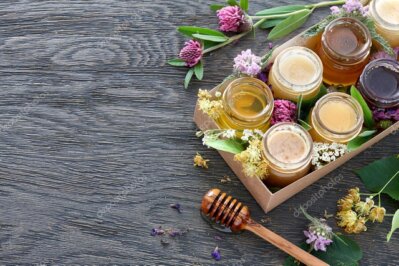 Vasetto di miele millefiori con fiori sullo sfondo
